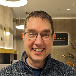 Photo of James Taylor looking very happy about being in a dessert restaurant.